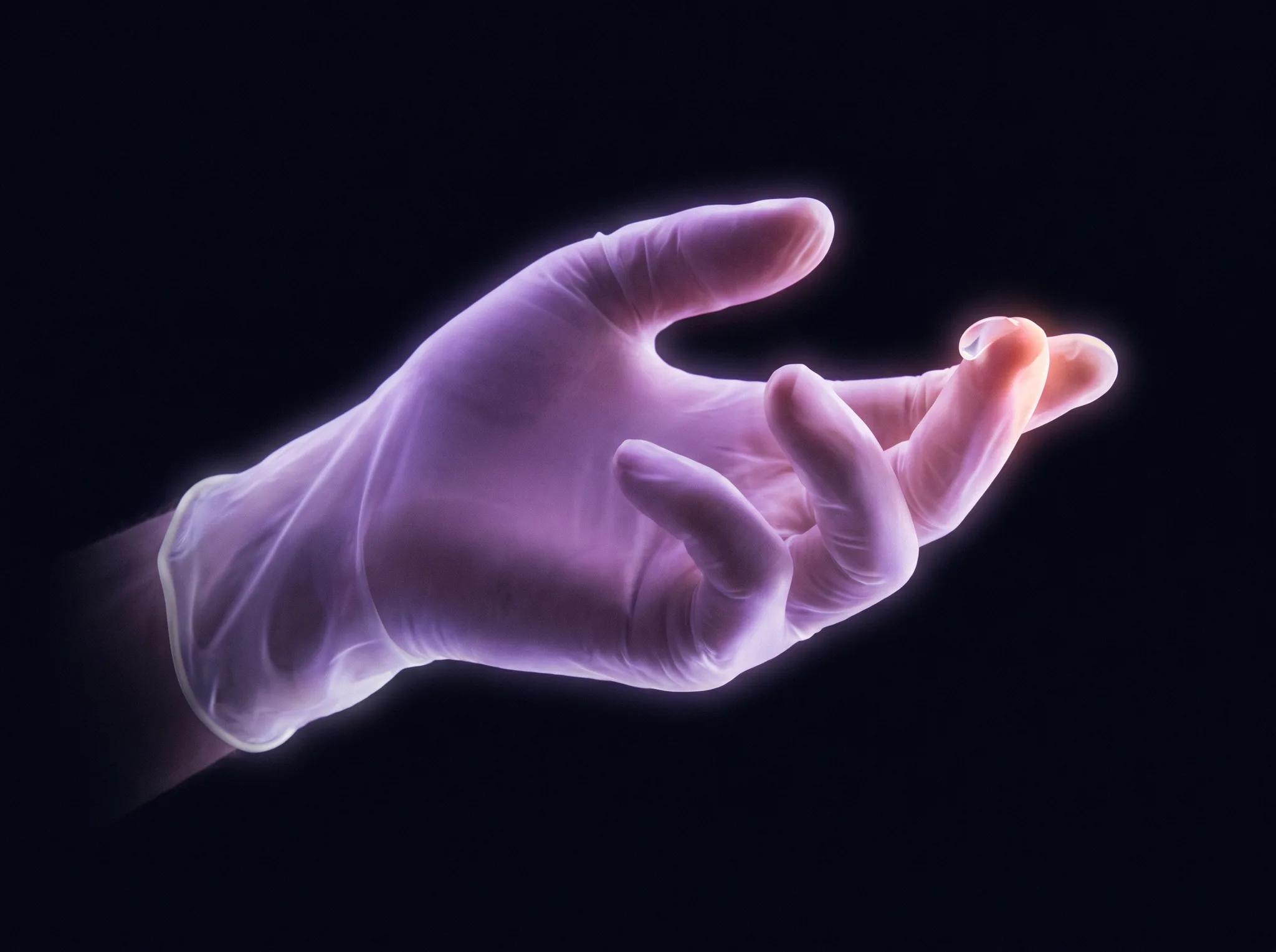A gloved hand drawn in pale light, index finger curled in a gentle beckoning arc, a bead of clear lubricant on the fingertip.